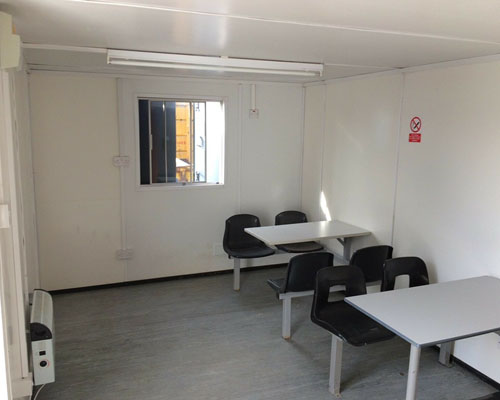 view of the canteen area with seating, showing window to rear in the portable office / canteen